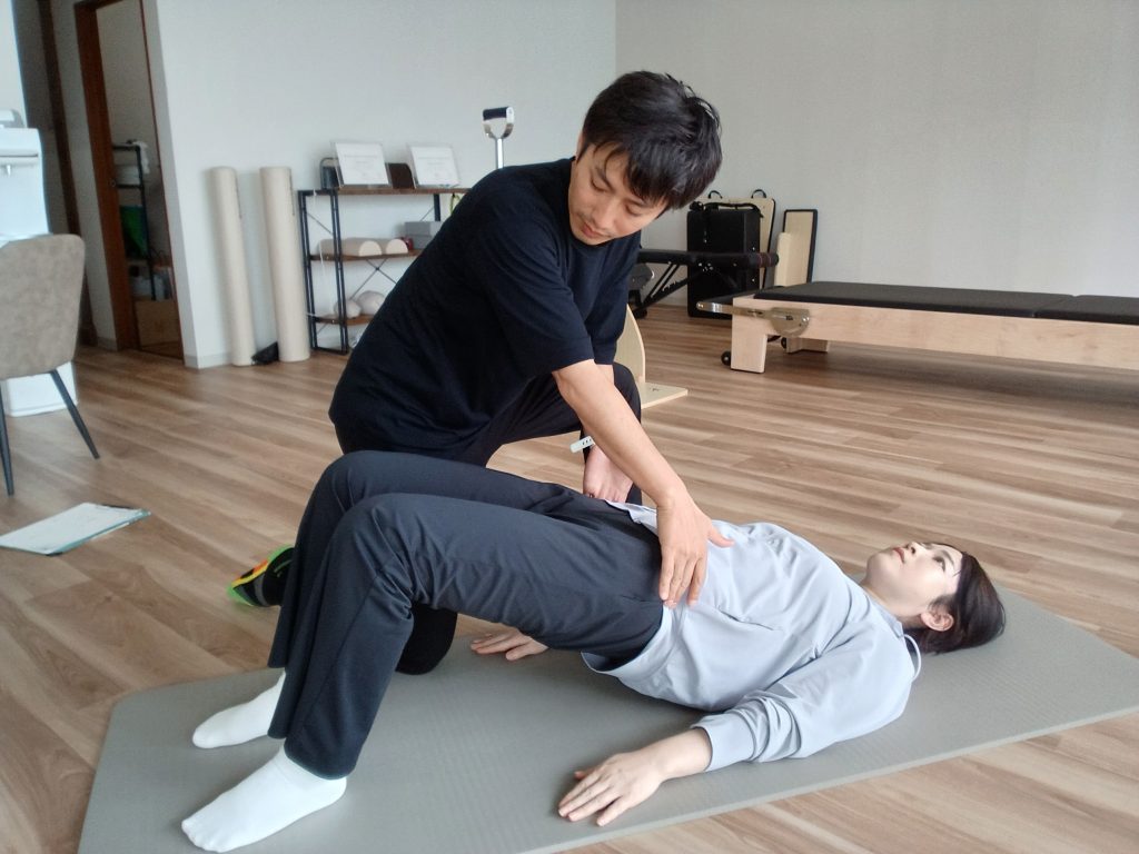 仰向けの運動で骨盤の動きを確認するパーソナルピラティスの様子