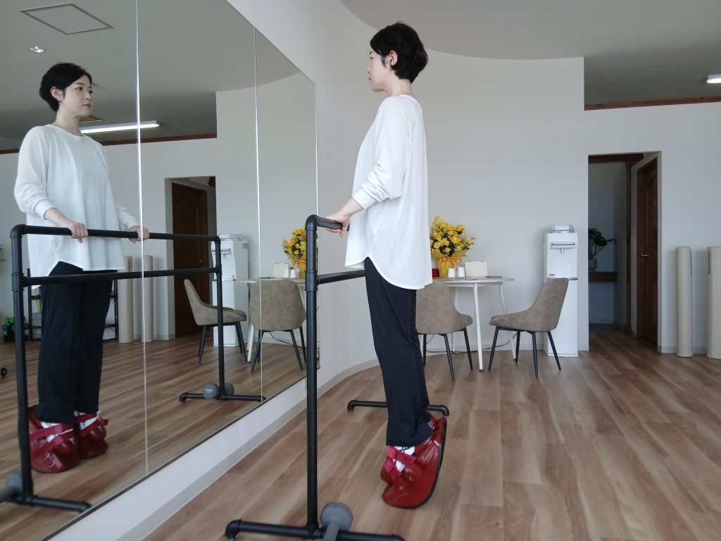 マスターストレッチの専用シューズを履いてバーを持つ女性